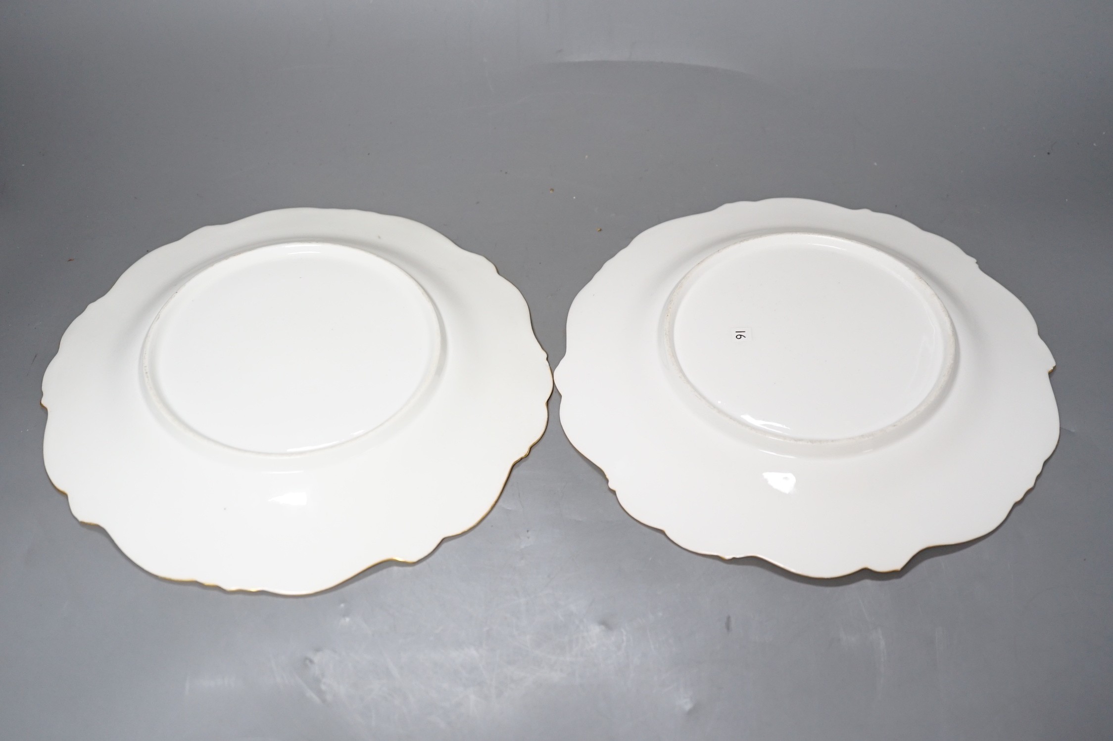 A pair of English porcelain plates with moulded white and turquoise borders both painted with landscapes, one titled in Guildford, diameter 22.5cm